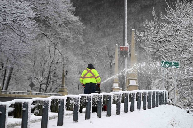 A Reading Public Works employee clears the walkway on the Lawrence J. Deisher Memorial Bridge, also known as the Lindbergh Viaduct, Monday, Feb. 23, 2026, following a less-than expected snowfall. (BILL UHRICH/READING EAGLE)