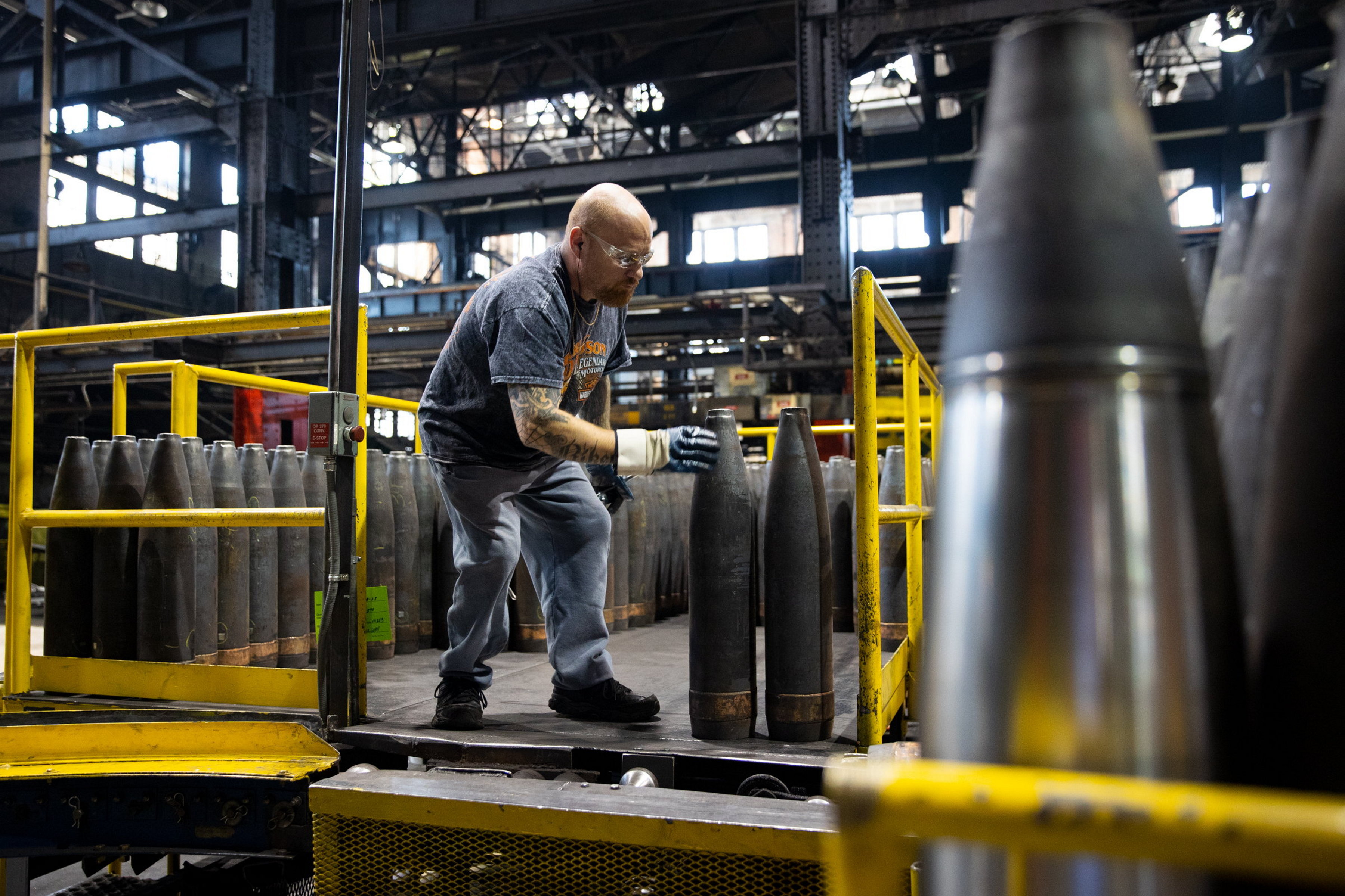 A General Dynamics worker moves 155mm shells along the assembly...