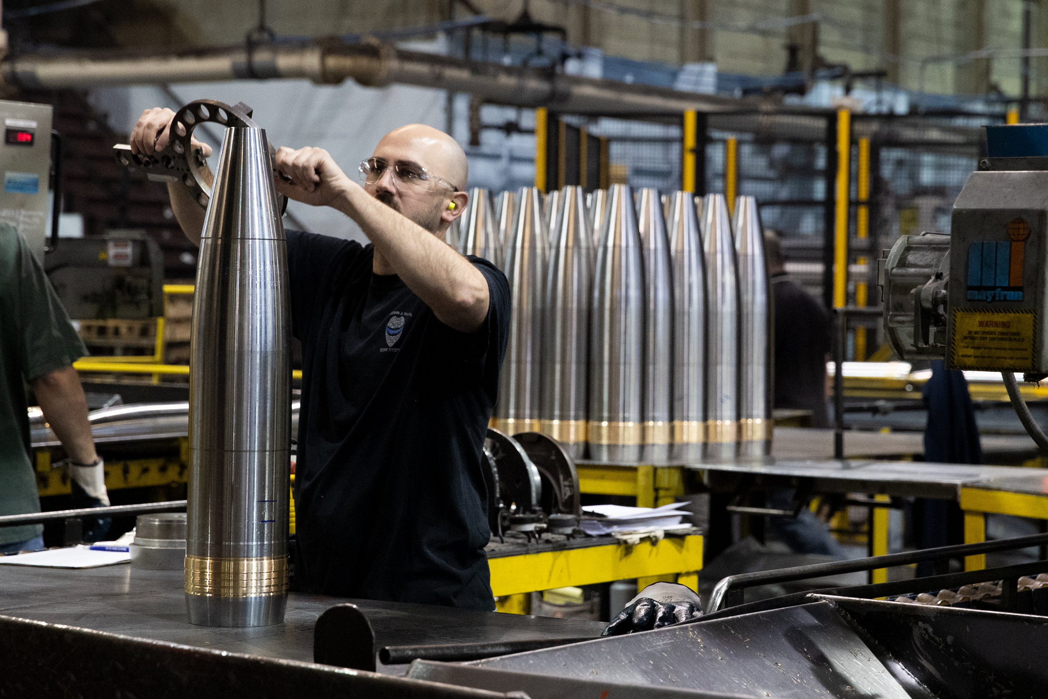 A worker assembles 155mm shells along the assembly line at...