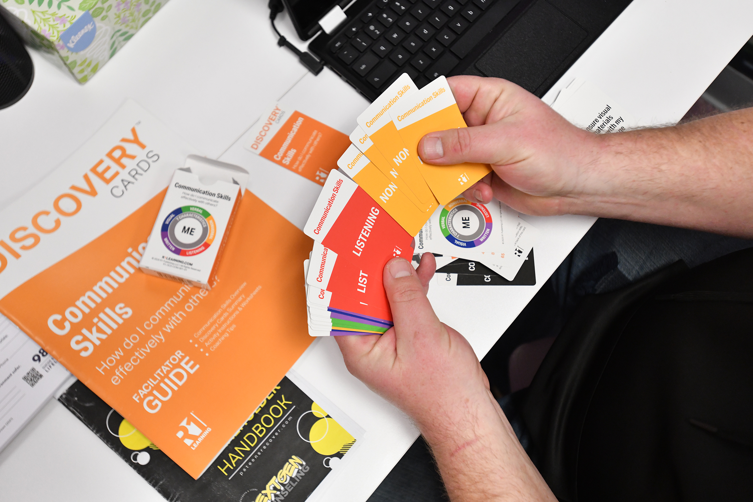 Founder of NextGen Counseling Jonathon Wasp holds communication cards used...