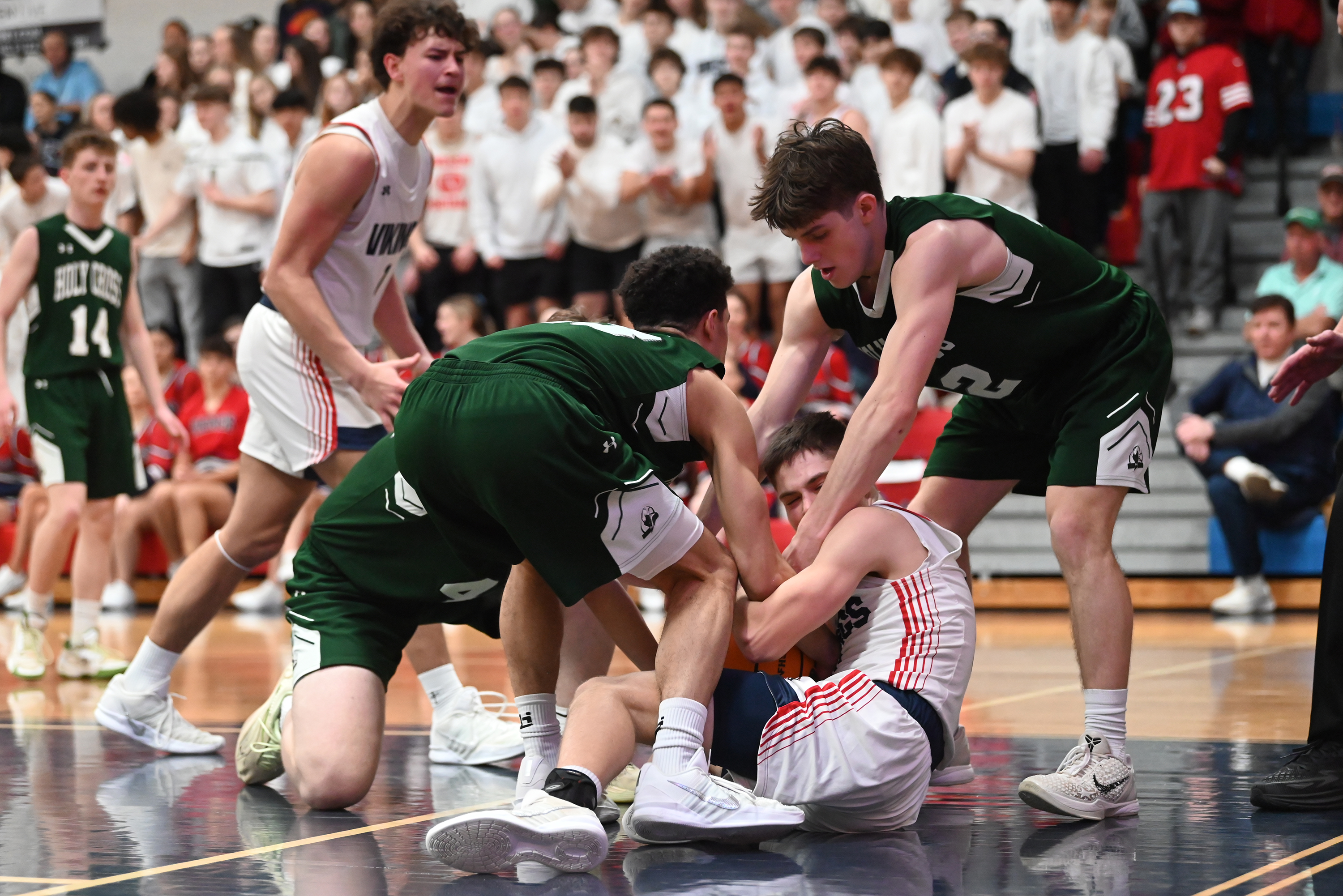 Holy Cross’ CJ Thompson and Jack Alpert attempt to take...