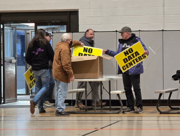 Dickson City residents pick up "No Date Center" signs during a public hearing on a data center ordinance at the Dickson City Civic Center on Thursday, Feb. 12, 2026. (FRANK WILKES LESNEFSKY / STAFF PHOTO)