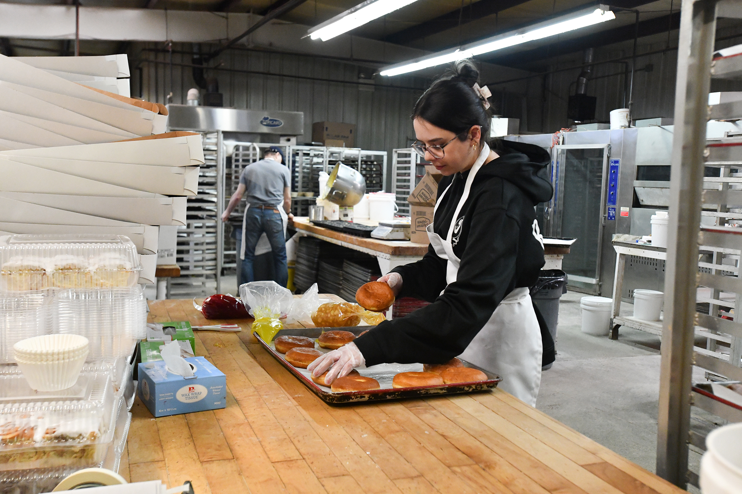 Manager Candace Fox finishes off a tray of pÄczki doughnuts...