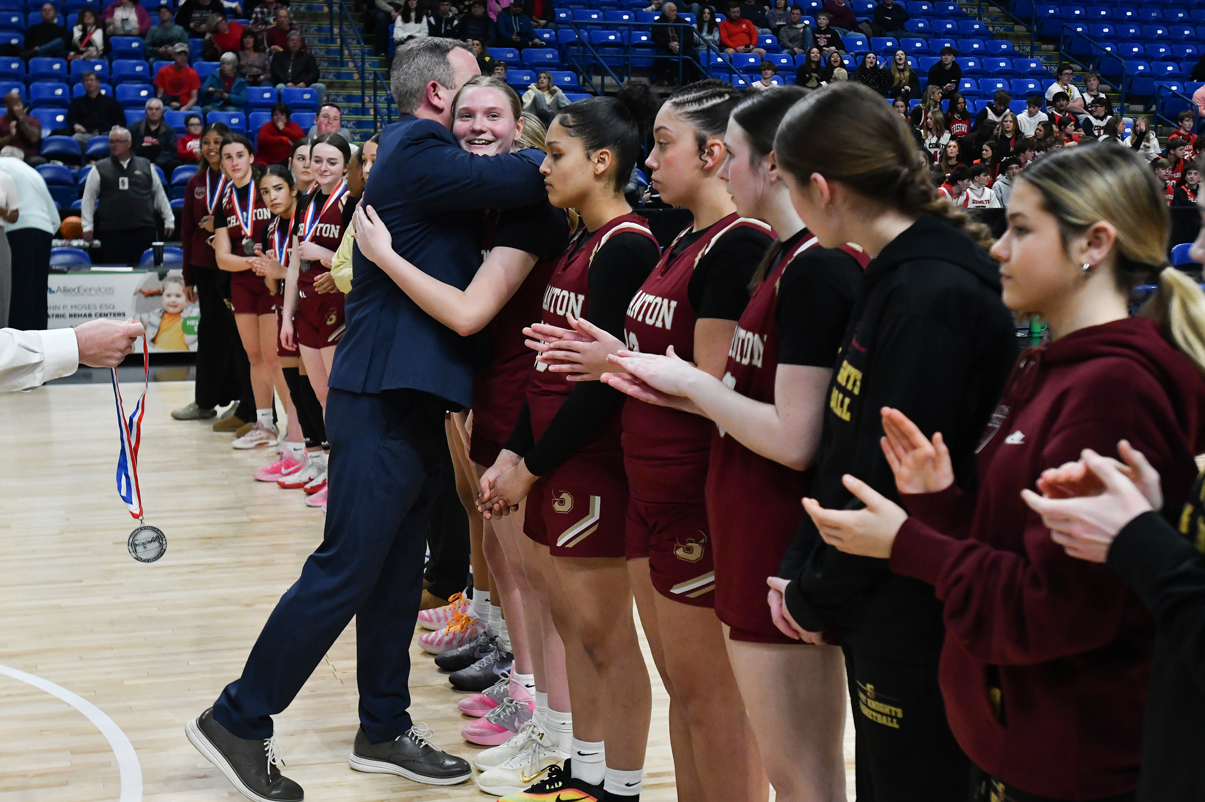 Scranton Head Coach PJ Hughes hugs player Abigail Stalica while...
