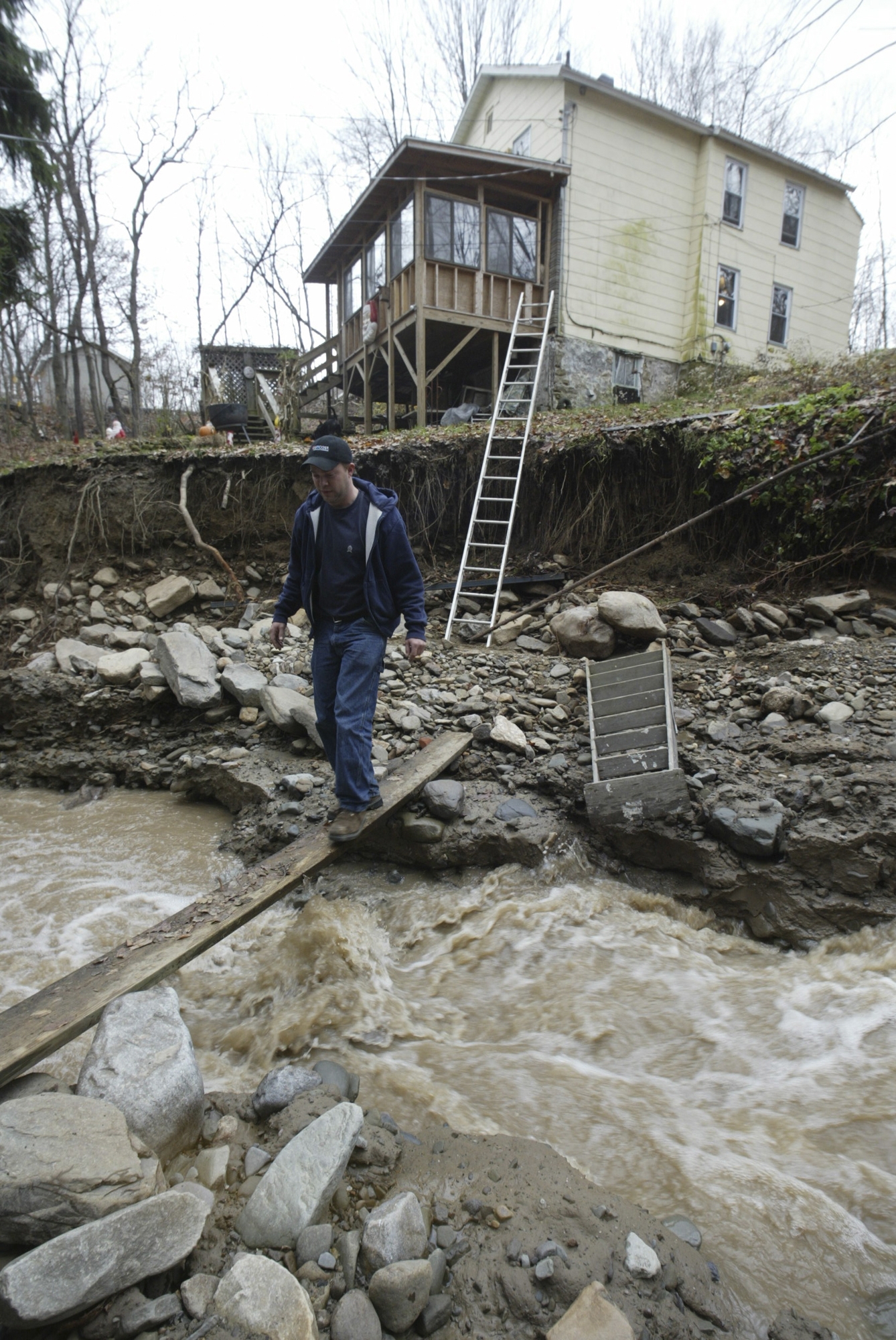 Jeff Jones walks across Lindy Creek on a plank at...