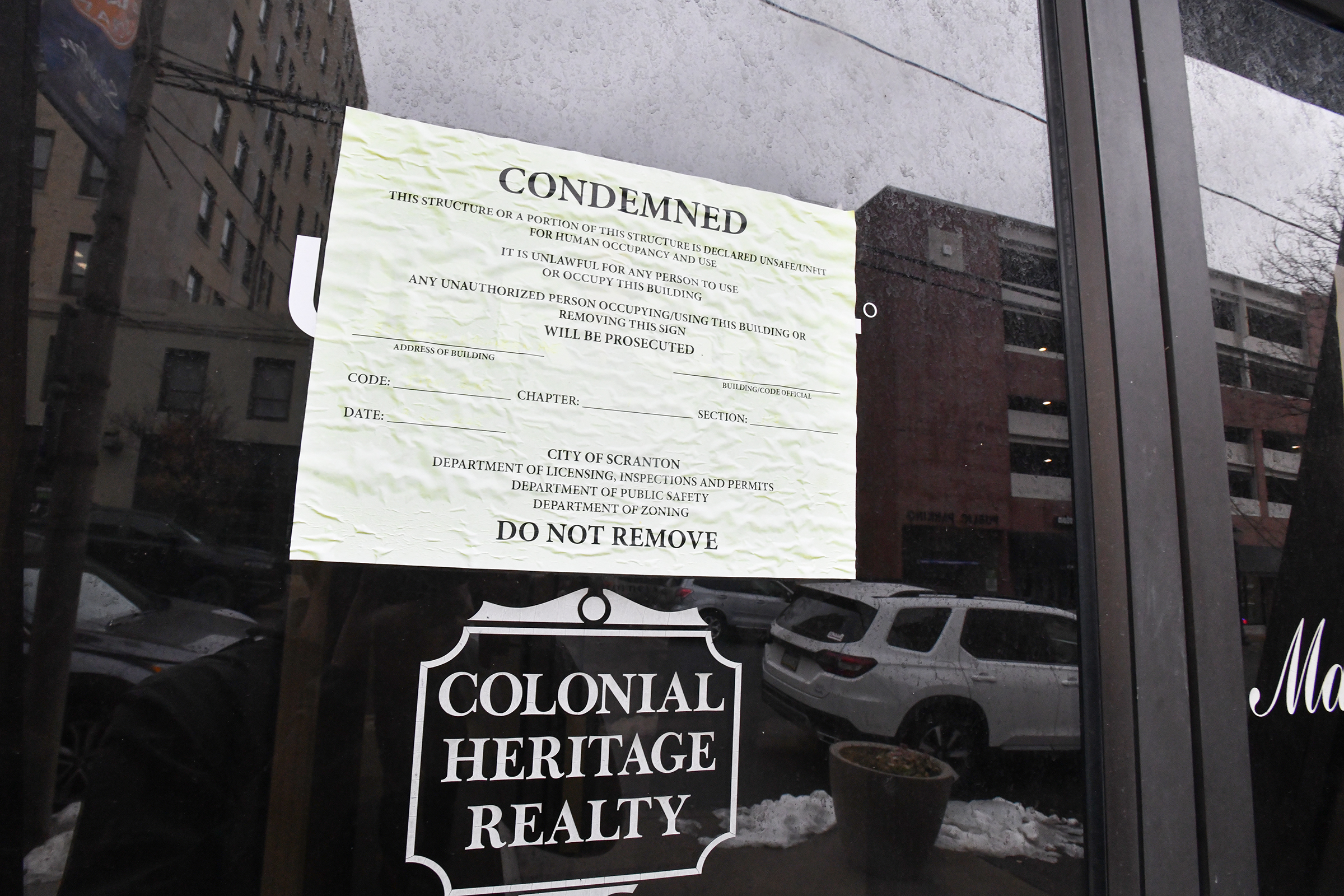 A condemned notice is placed on the front door of...