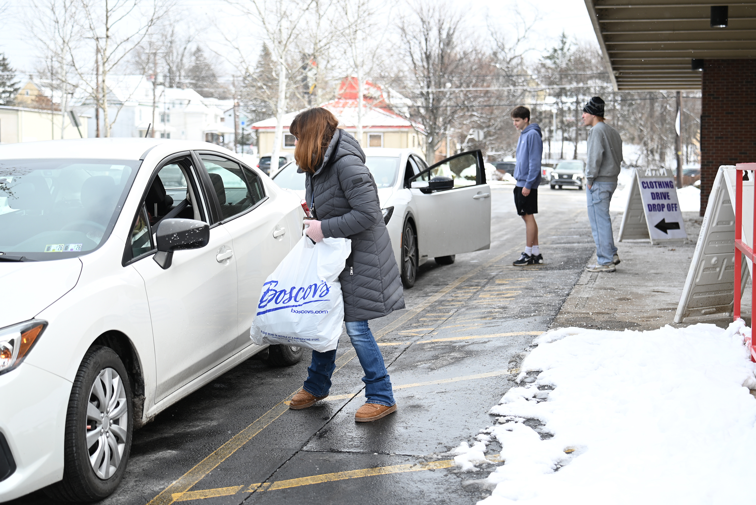 Volunteers gather donations from waiting cars during the children's clothing...