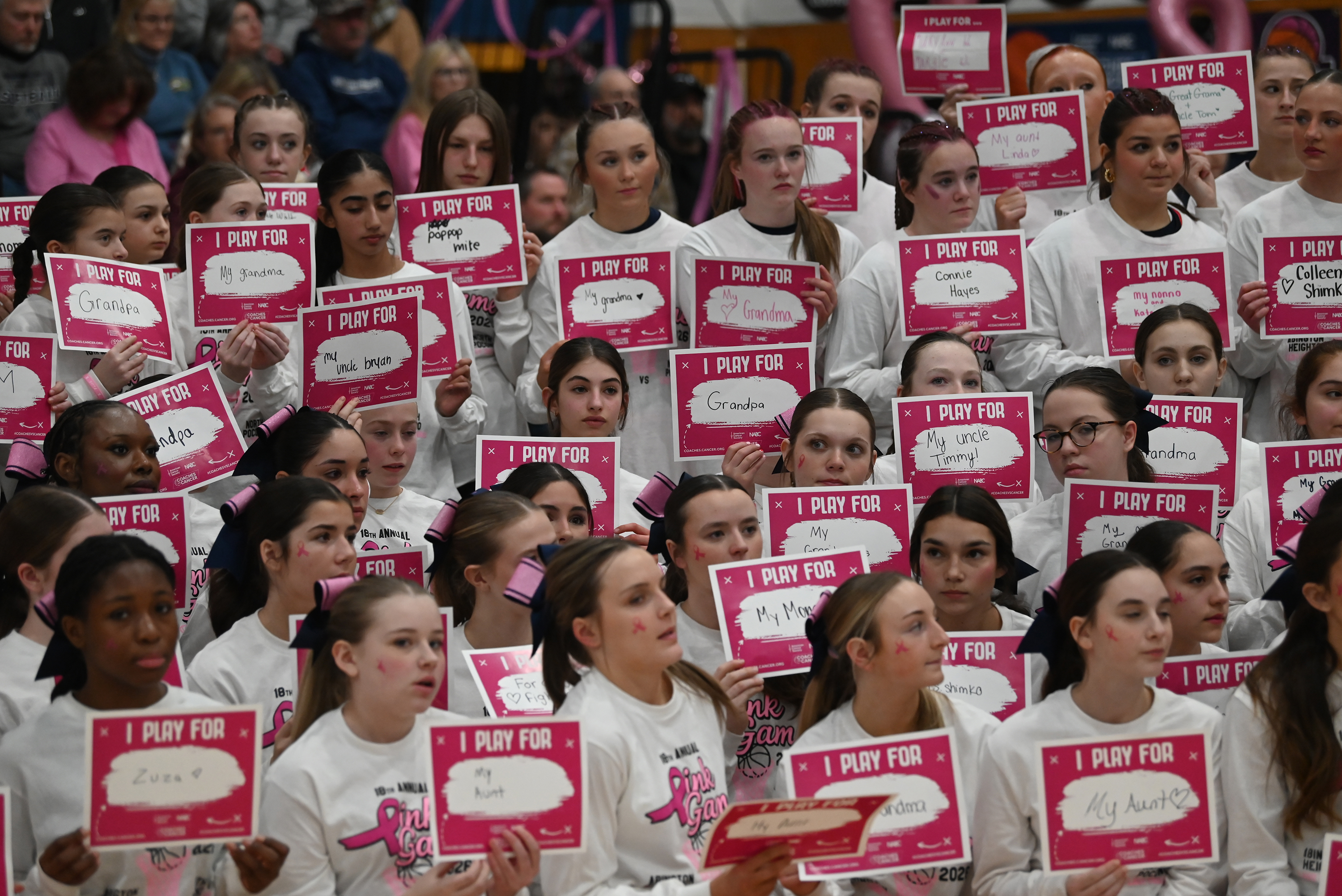 Students hold signs say who they’re playing for during the...