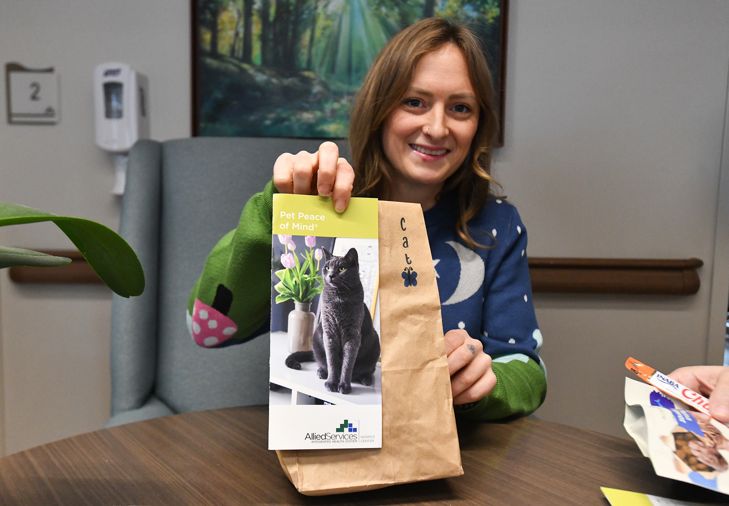Volunteer Rebecca Farrell holds up a brochure attached to a...