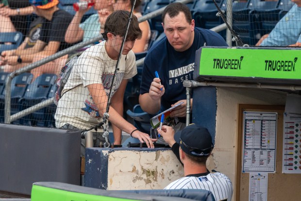 Fans get an autograph from the RailRiders' T.J. Rumfield before Wednesday's game at PNC Field in Moosic. (REBECCA PARTICKA / STAFF PHOTOGRAPHER)