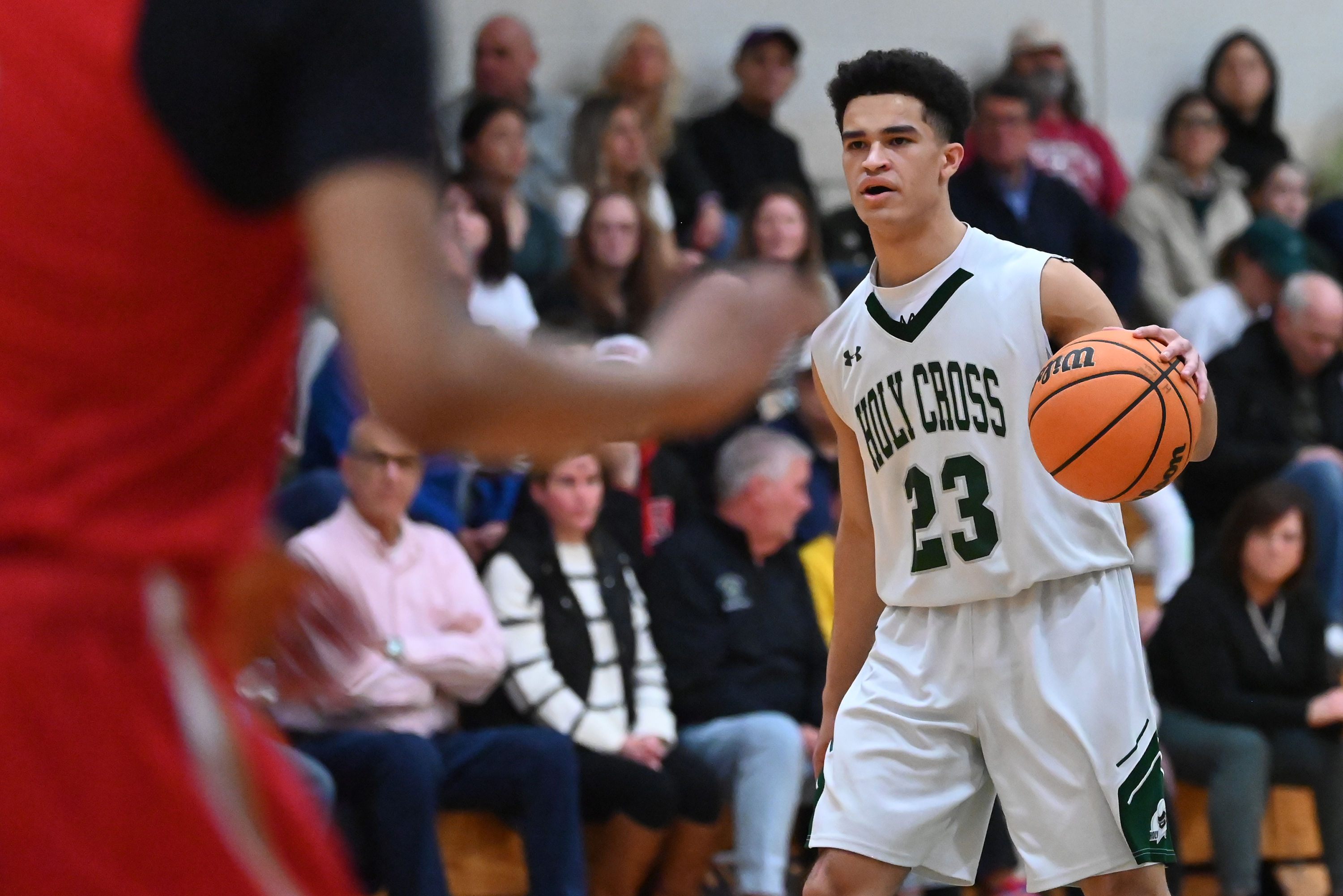 Holy Cross’ CJ Thompson controls the ball during the basketball...