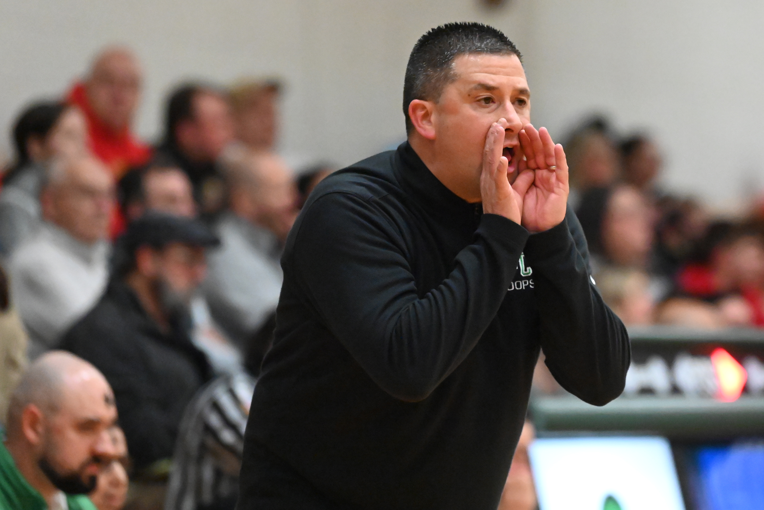 Holy Cross’ head coach Al Callejas Jr. calls out to...