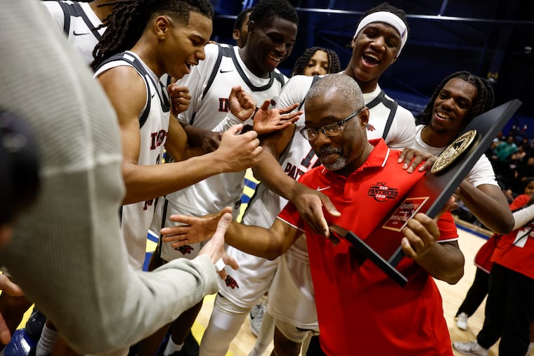Imhotep Institute Charter players celebrate with their head coach Andre Noble after winning the PPL Boys Basketball Championship.
