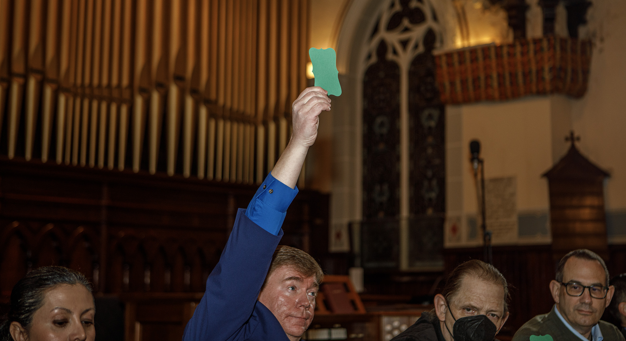 Lamont McClure, a Democratic candidate, holds up a green card...