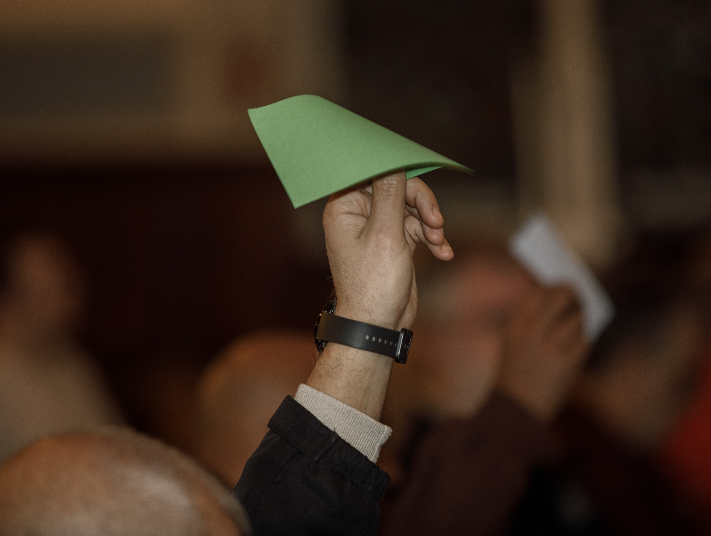 A green card is held up in favor of a...