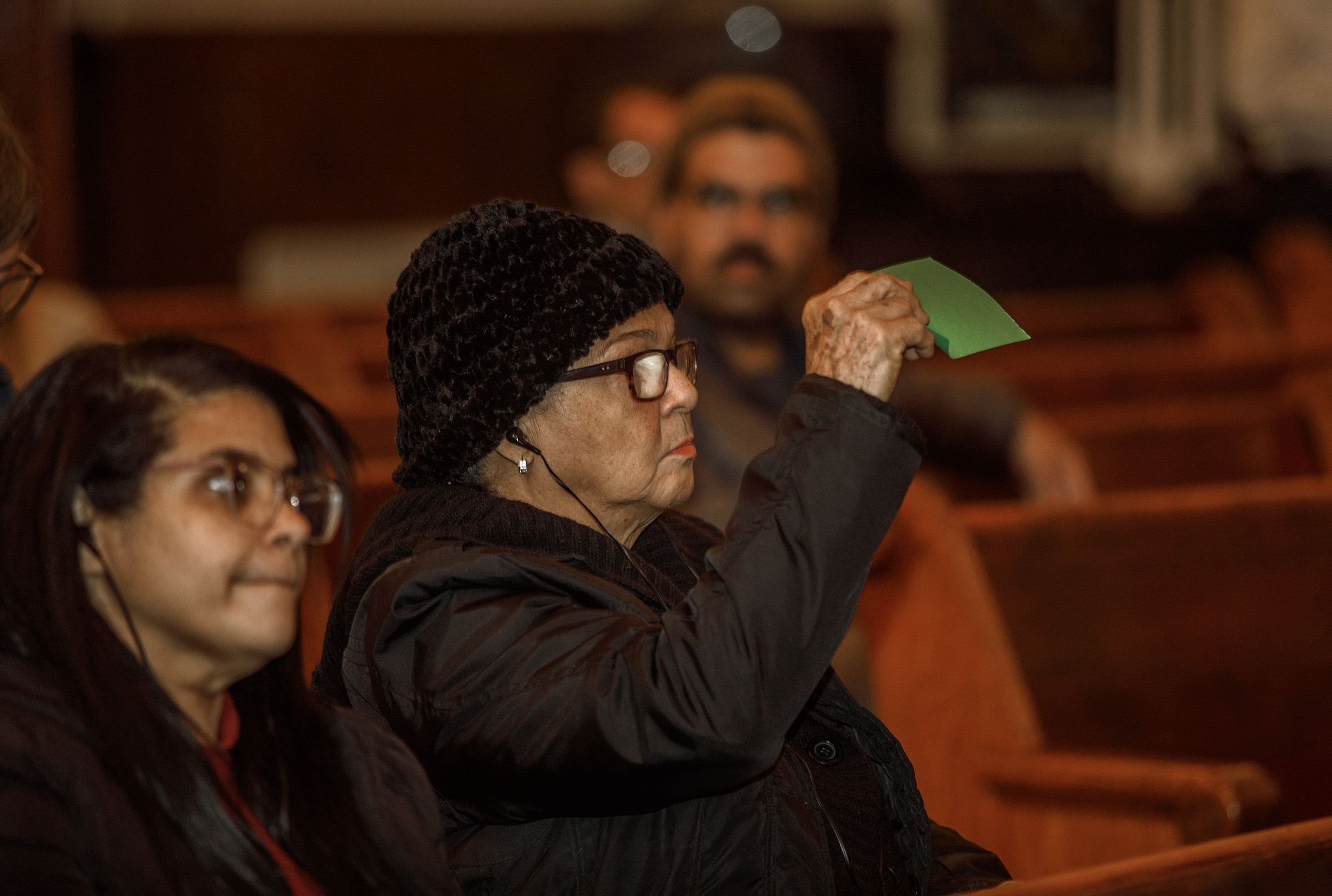 Angela Madera of Allentown holds up a green card in...