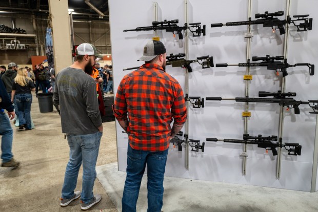 Two men look at guns and ammunition at the Great American Outdoor Show on Feb. 9, 2024, in Harrisburg, Pennsylvania. Held at the Pennsylvania Farm Show Complex, it features more than 1,000 exhibitors showing off the latest in weapons, hunting accessories and other outdoor items. (Spencer Platt/Getty Images/TNS)