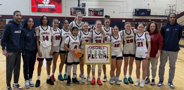 Ava Kopetskie with her teammates and coaches after becoming Liberty's all-time leading scorer in girls basketball. (Photo courtesy of Derek Bast)