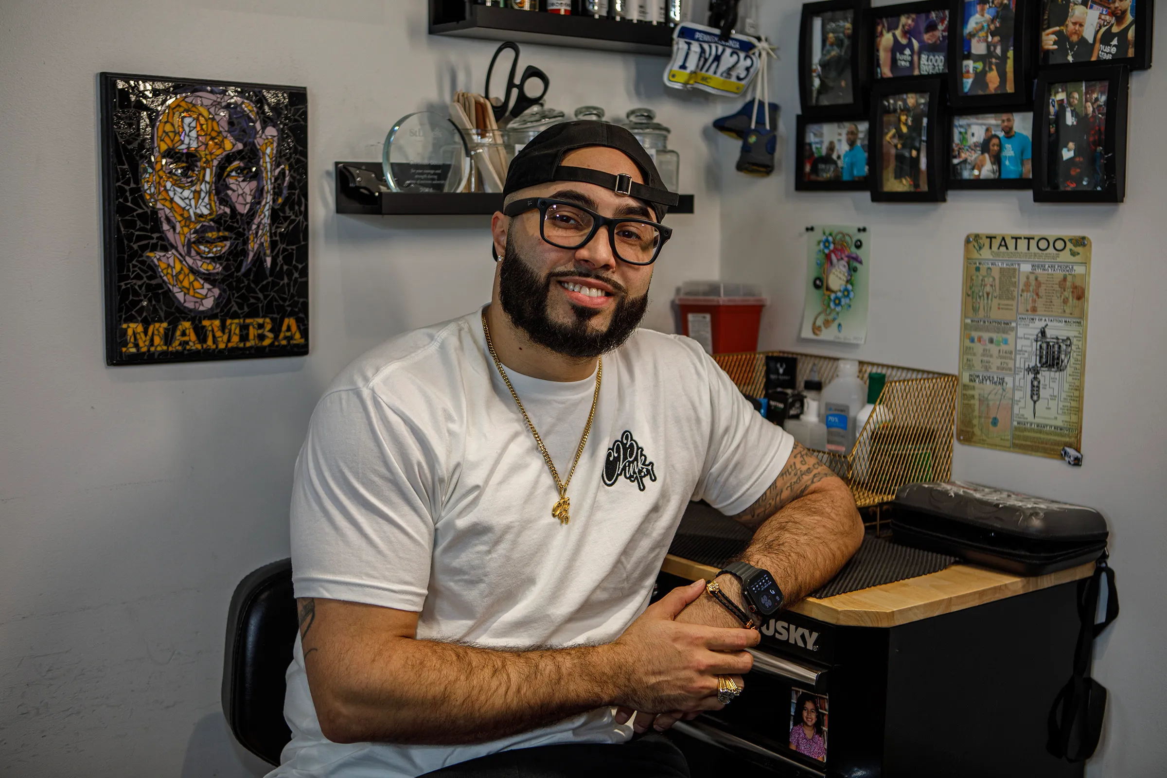 Tattoo artist Christian Colon sits at his tattoo station inside...