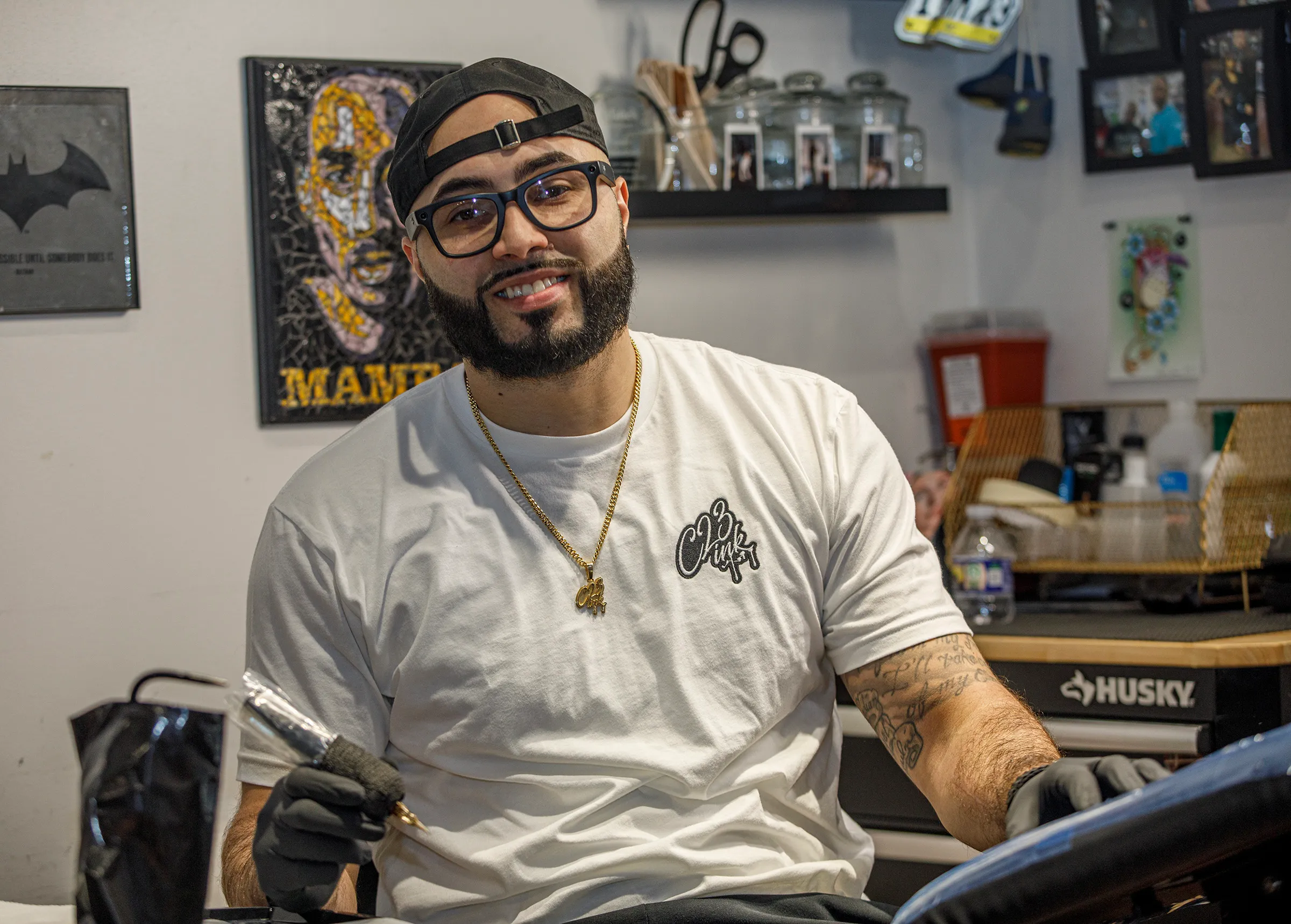 Tattoo artist Christian Colon sits at his tattoo station inside...