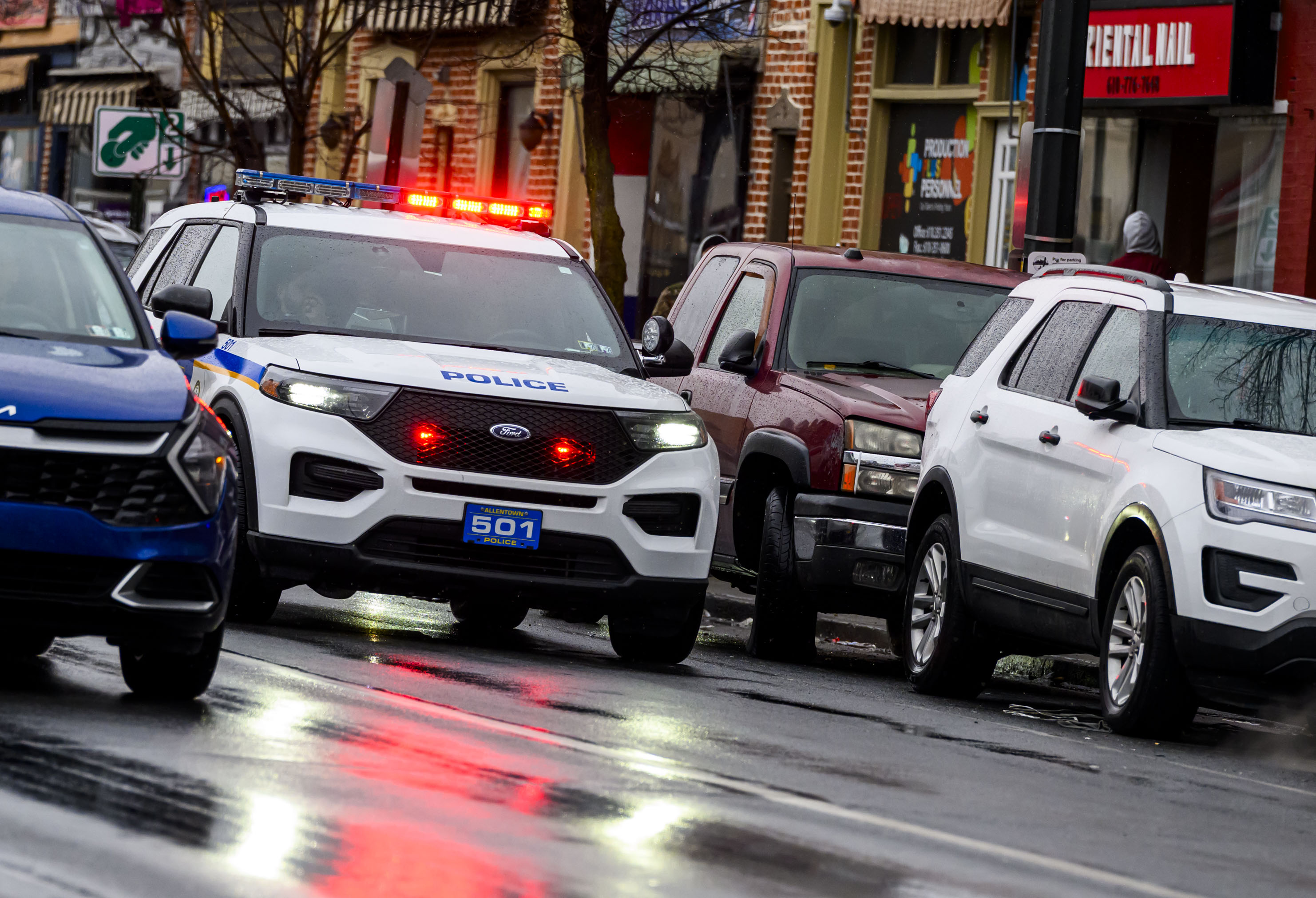 Allentown police drive slowly past parked vehicles Sunday, Feb. 22, 2026, announcing over a loud speaker that vehicles must be moved or will be ticketed and towed due to being parked along a snow emergency route on Seventh Street in Allentown. The city declared an emergency ahead of a winter storm Sunday into Monday that was expected at various points to drop anywhere from 7 to 18 inches of snow in the region. (April Gamiz/The Morning Call)