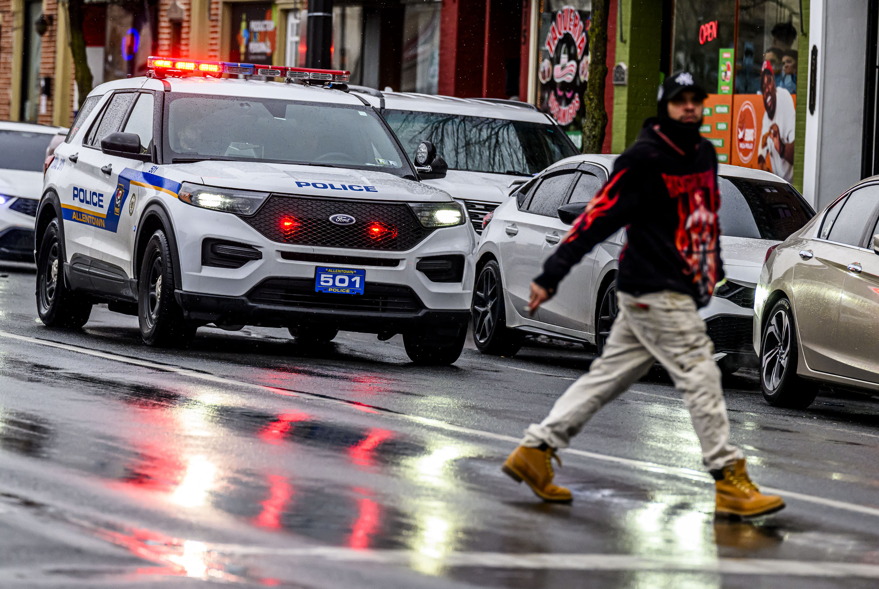 Allentown police drive slowly past parked vehicles Sunday, Feb. 22, 2026, announcing over a loud speaker that vehicles must be moved or will be ticketed and towed due to being parked along a snow emergency route on Seventh Street in Allentown. The city declared an emergency ahead of a winter storm Sunday into Monday that was expected at various points to drop anywhere from 7 to 18 inches of snow in the region. (April Gamiz/The Morning Call)