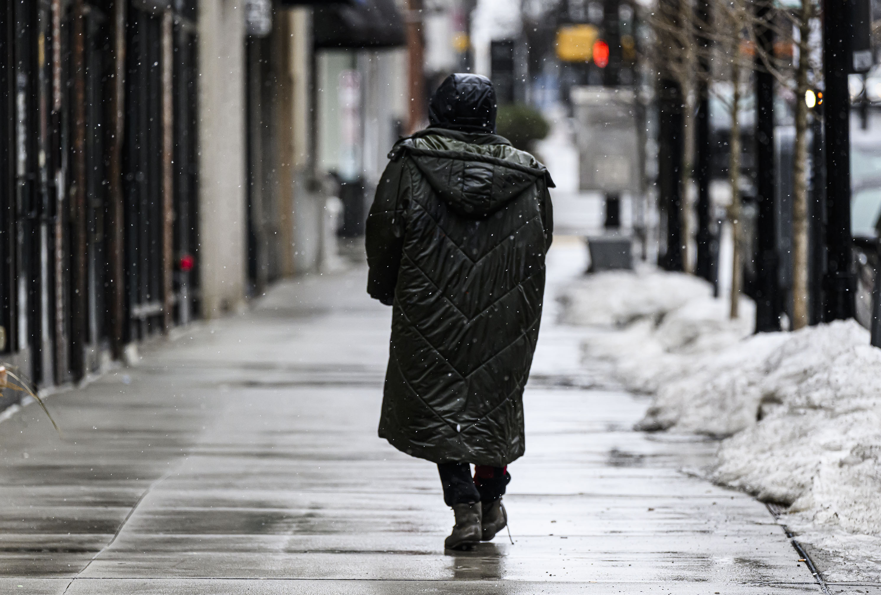 A pedestrian walks on Hamilton street on Sunday, Feb. 22, 2026, as the weather changed from rain to flurries in Allentown. A winter storm was expected to drop 7-14 inches of snow in the region Sunday into Monday, though the National Weather Service said there was a lot of uncertainty about the total. (April Gamiz/The Morning Call)