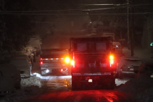 City trucks plow as snow falls late in the evening Sunday, Feb. 22, 2026, in Bethlehem. A winter storm was expected to drop 7-14 inches of snow in the region Sunday into Monday, though the National Weather Service said there was uncertainty about the total. (Rich Rolen/Special to The Morning Call)
