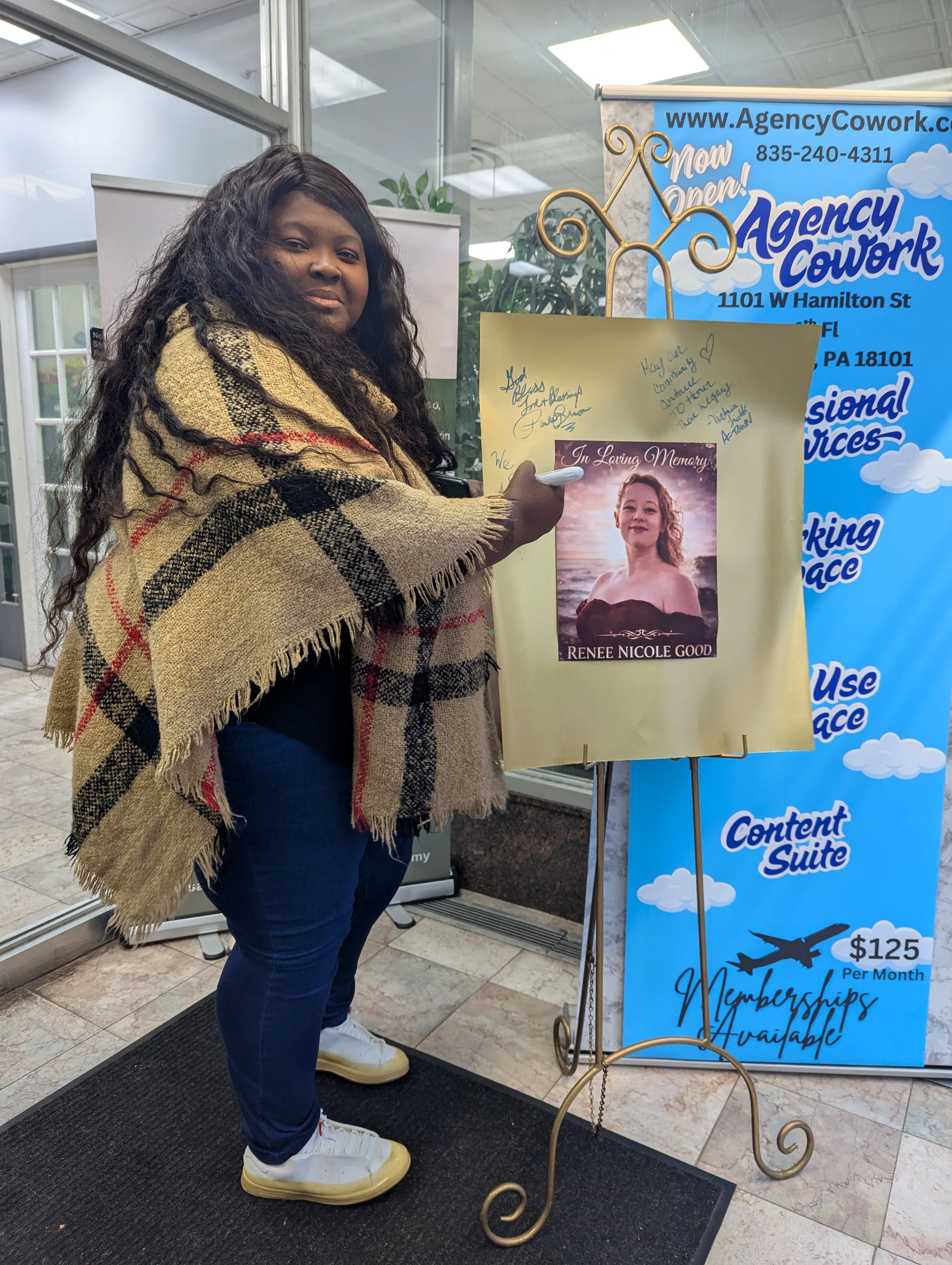 Victoria Fields signs a tribute poster for Renee Good, the...
