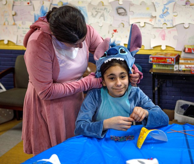Jamie Gordon-Rodriguez of Allentown, as Angel of Lily and Stitch, dresses her daughter Iris Gordon, 9, as Stitch, during a Purim celebration Wednesday, Feb. 25, 2026, at the Jewish Day School of the Lehigh Valley in Allentown. Purim celebrates the biblical story of Esther's deliverance of the Jews in Persia from a massacre plotted by Haman. The holiday, which is marked by the retelling of the Book of Esther, gift giving, meals and costumes, begins this year on Monday evening and continues into Tuesday, March 3, 2026. (Jane Therese/Special to The Morning Call)