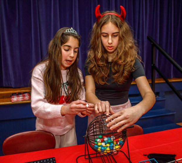 Ariana Bub of Allentown, and Gabby Bragin of Easton organize the Bingo table prior to a Purim celebration Wednesday, Feb. 25, 2026, at the Jewish Day School of the Lehigh Valley in Allentown. Purim celebrates the biblical story of Esther's deliverance of the Jews in Persia from a massacre plotted by Haman. The holiday, which is marked by the retelling of the Book of Esther, gift giving, meals and costumes, begins this year on Monday evening and continues into Tuesday, March 3, 2026. (Jane Therese/Special to The Morning Call)
