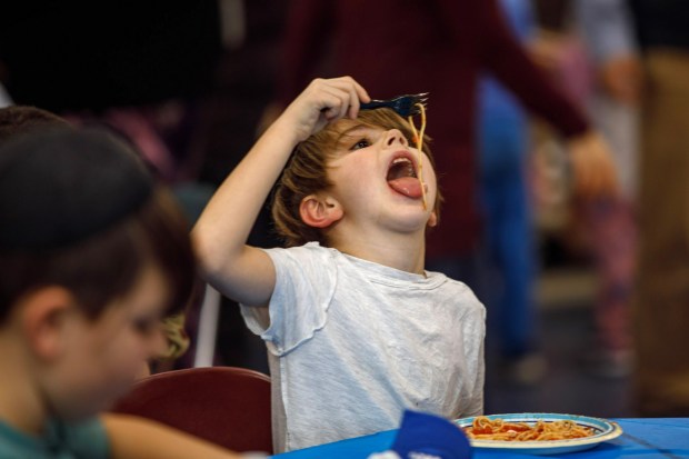 Ira Toff, 7, of Allentown enjoys his pasta dinner during a Purim celebration Wednesday, Feb. 25, 2026, at the Jewish Day School of the Lehigh Valley in Allentown. Purim celebrates the biblical story of Esther's deliverance of the Jews in Persia from a massacre plotted by Haman. The holiday, which is marked by the retelling of the Book of Esther, gift giving, meals and costumes, begins this year on Monday evening and continues into Tuesday, March 3, 2026. (Jane Therese/Special to The Morning Call)