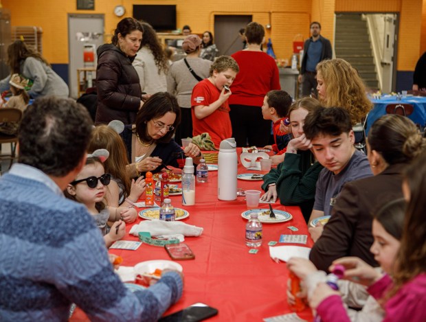 Guests enjoy food and games during a Purim celebration Wednesday, Feb. 25, 2026, at the Jewish Day School of the Lehigh Valley in Allentown. Purim celebrates the biblical story of Esther's deliverance of the Jews in Persia from a massacre plotted by Haman. The holiday, which is marked by the retelling of the Book of Esther, gift giving, meals and costumes, begins this year on Monday evening and continues into Tuesday, March 3, 2026. (Jane Therese/Special to The Morning Call)