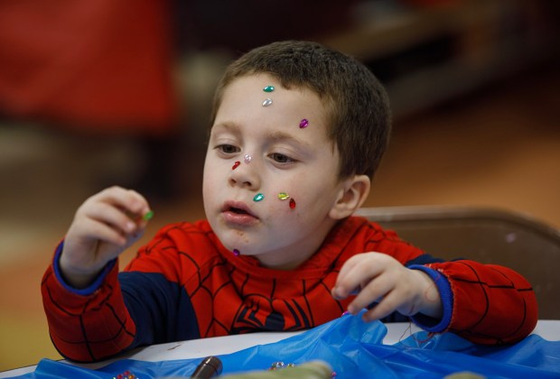 Raz Saltz, 5, of South Whitehall Township decorates his face with sticky gems during a Purim celebration Wednesday, Feb. 25, 2026, at the Jewish Day School of the Lehigh Valley in Allentown. Purim celebrates the biblical story of Esther's deliverance of the Jews in Persia from a massacre plotted by Haman. The holiday, which is marked by the retelling of the Book of Esther, gift giving, meals and costumes, begins this year on Monday evening and continues into Tuesday, March 3, 2026. (Jane Therese/Special to The Morning Call)