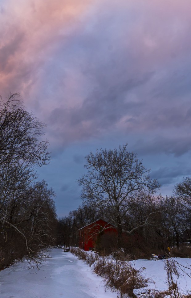 A streak of pink clouds moves through the sky above the frozen Lehigh Canal at sunset Wednesday, Feb 11, 2026, at Sand Island Park in Bethlehem. Starting this week, the sun sets after 5:30 p.m. (April Gamiz/The Morning Call)