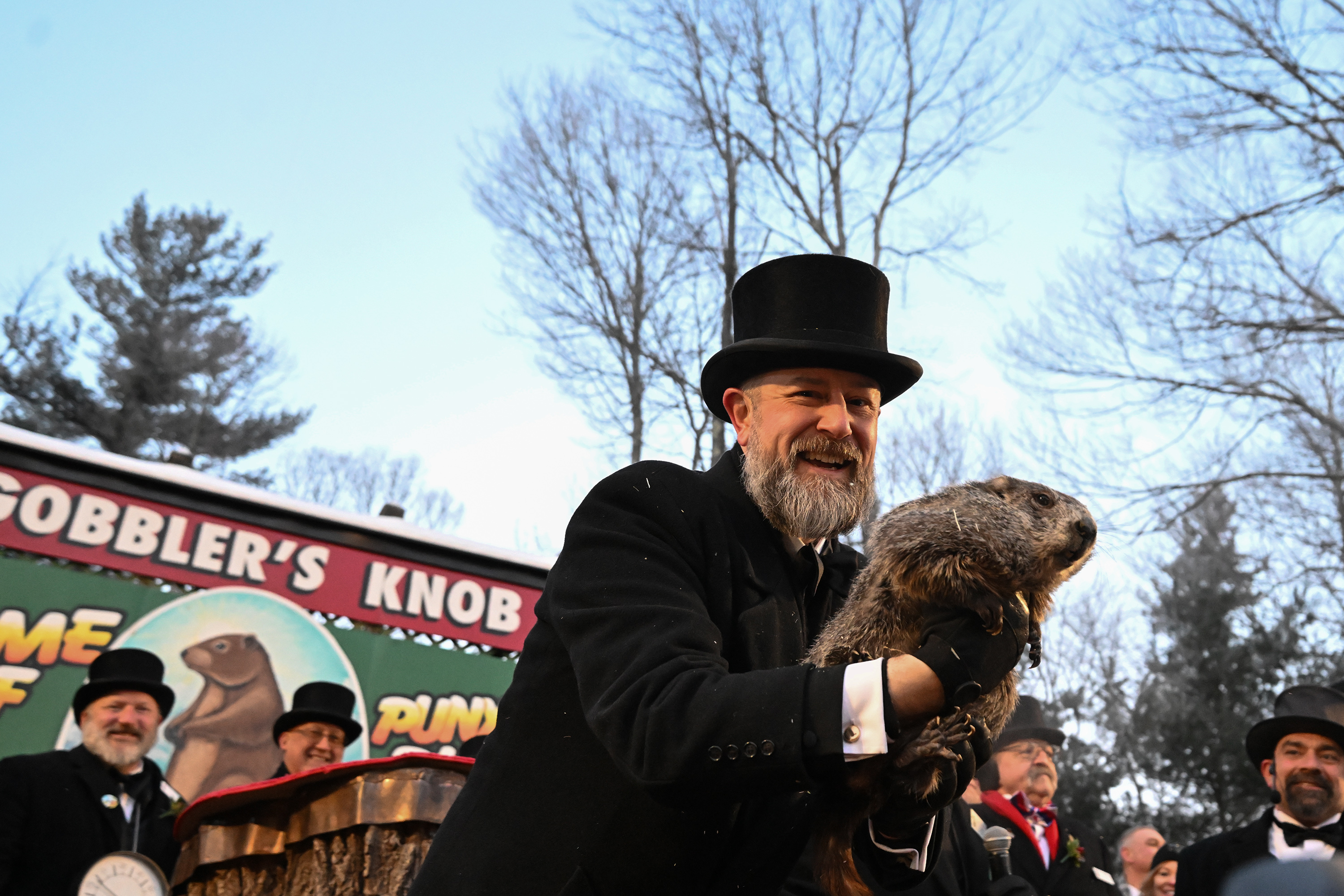 Groundhog Club handler A.J. Dereume holds Punxsutawney Phil, the weather...
