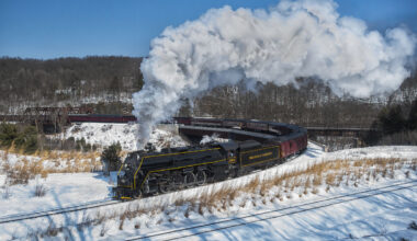 Black steam locomotive on a curve in a snowy landscape. Reading & Northern No. 2102 winter rambles.