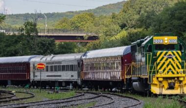 Passenger train with green and yellow diesel rounding curve