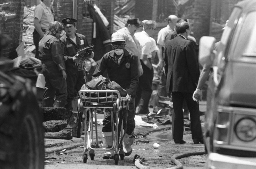 A worker transports the remains of a body found within the debris of the house of the MOVE compound in West Philadelphia