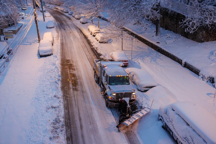 Sanitation Department dump truck clears snow on Midvale Avenue in the East Falls section of Philadelphia on Monday, Feb. 23, 2026. On Wednesday, Feb. 25, sanitation crews will resume trash and recycling collection.