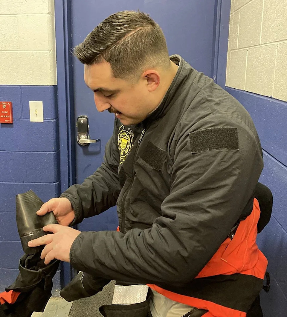 Coast Guard Petty Officer 2nd Class Gage Downer inspects a repair he made on the sleeve of an ice rescue suit before a rescue drill Feb. 3 at Coast Guard Station Erie at Presque Isle State Park.