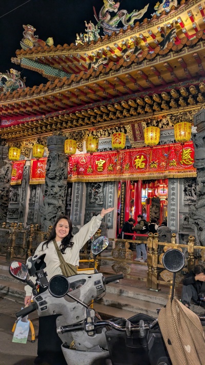 young woman with motorscooter infront ot decorative Taiwan building
