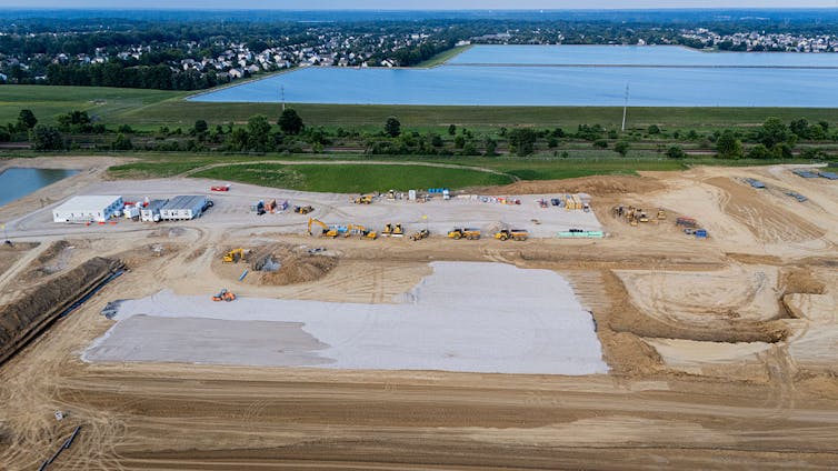 Construction vehicles and equipment surround  AI data center.