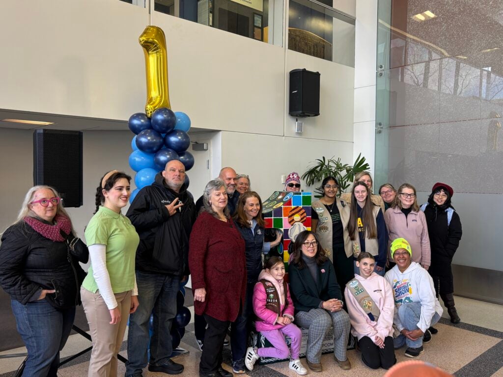 A large group of people posing with the 1 statue
