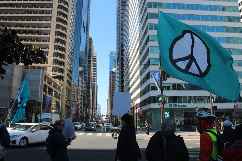 People hold signs in Philadelphia protesting war in Iran