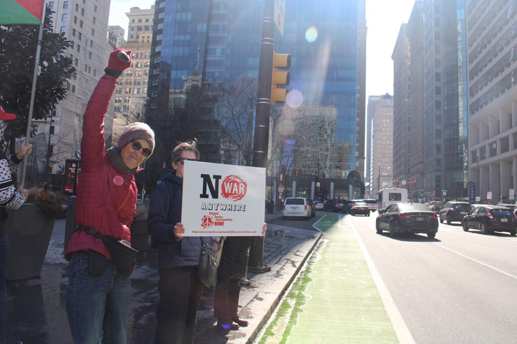 People hold signs in Philadelphia protesting war in Iran