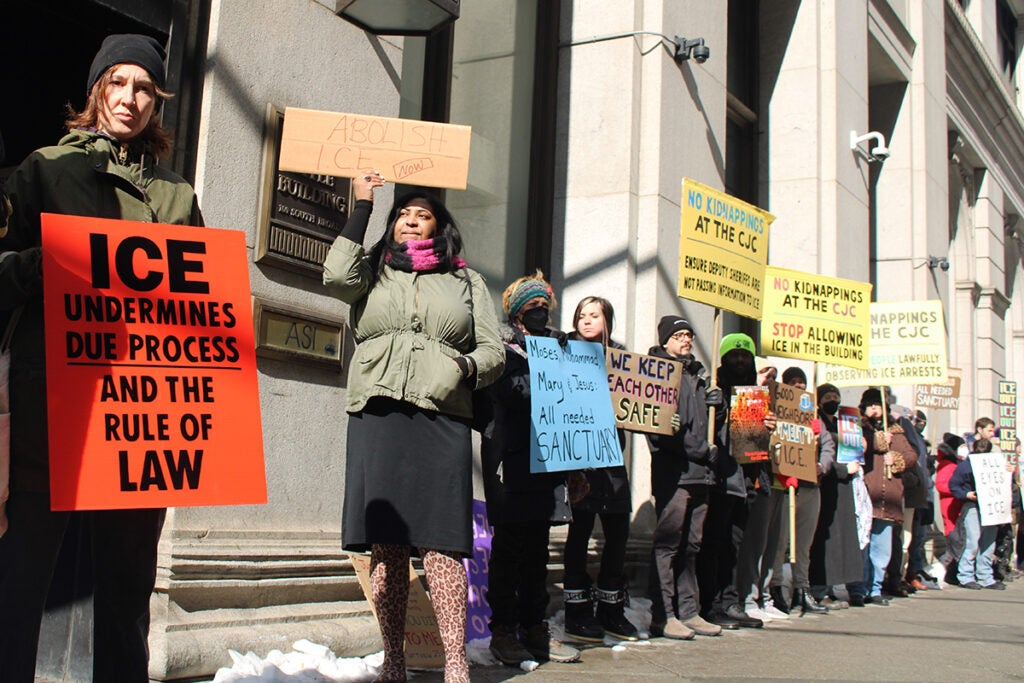 Protesters hold up handmade signs outside the Criminal Justice Center