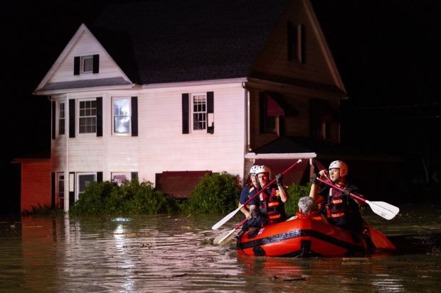 Scranton firefighters from Rescue 1 arrive in a boat at Jackson Street and South Merrifield Avenue in West Scranton with a woman rescued from a flooded home on Saturday, Sept. 9, 2023.