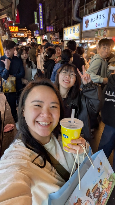 tow young women at busy, night street market, Taiwan