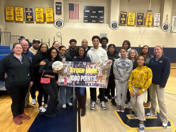 Pope John Paul II senior guard Ayden Wise (white sweatshirt, holding sign) became the first player in program history to reach 1,000 career points in the Golden Panthers' 71-44 win over Lower Moreland in the District 1-4A semifinals on February 17, 2026. (Photo courtesy Earl Wise)